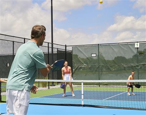 A group of people playing pickleball