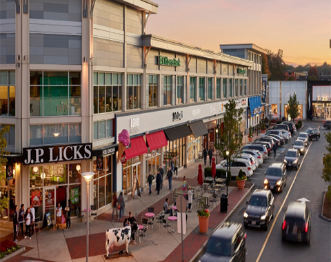A store on the corner of a busy street that has a sign saying,