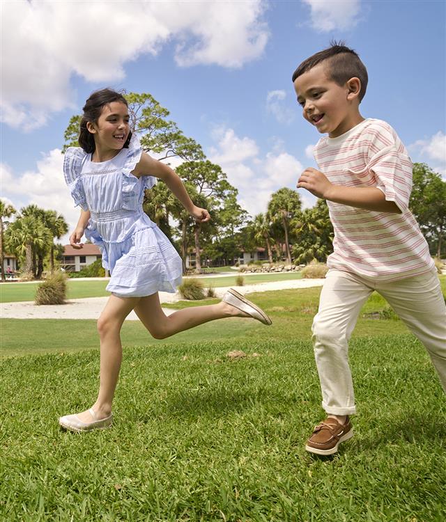 Two kids running on lawn